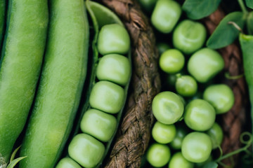 Close-up of fresh green peas and pea pods with leaves just plucked from the garden . Healthy food...