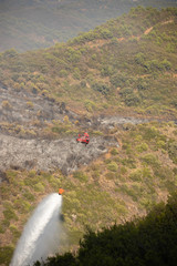 Helicopters putting out a forest fire in the Sierra Bermeja mountains in Estepona, Spain