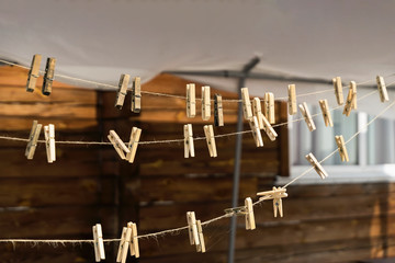 Several old wooden clothespins on a rope, rustic background