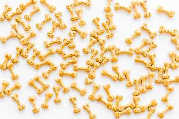 Dog dry food in shape of bone on white background top view pattern