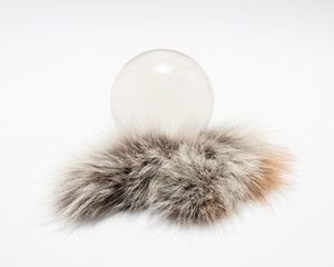 Magic glass ball, isolated on fur and white background.