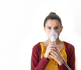 Young woman doing inhalation nebulizer in hospital, holding a mask nebuliser inhaling asthma and...