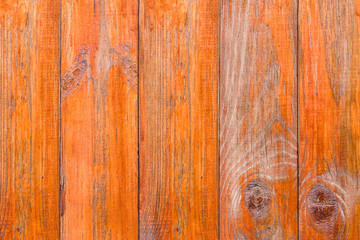 Old wooden boards with peeling paint. Wooden fence. Grunge style. Orange paint.