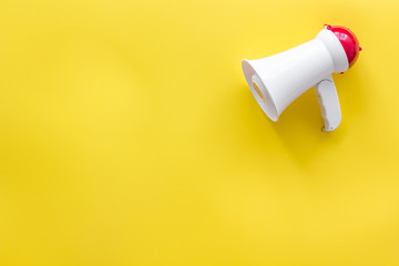 Announcement with megaphone on yellow background top view mockup