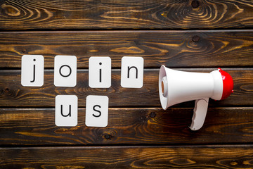 Join us text for announcement and megaphone on wooden background top view