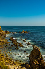 sunset at Corona del Mar State Beach CA USA with great view of the ocean, sun, stone formation, and light
