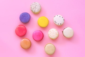 Fototapeta na wymiar French colorful macaroons cakes flat lay. Small sweet biscuits isolated on pink background. Dessert. Happy bithday and valentine’s day creative minimal concept. Confectionery. Bakery design element.
