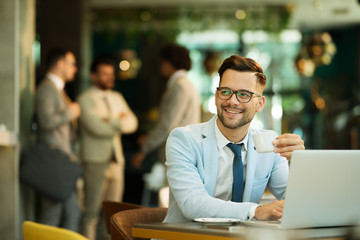 Young businessman uses a laptop in a cafe