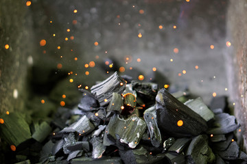 Red hot sparks flying out of burning coals. Summer holidays and barbecue