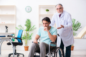 Male patient in wheel-chair visiting old doctor