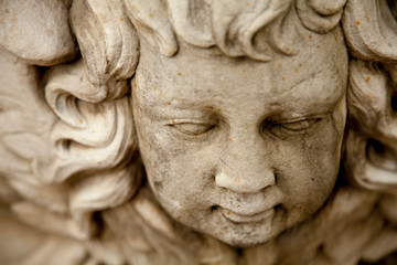 Top view of ancient statue of angel with wings. Selective focus.