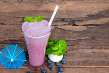 Blueberry smoothies purple colorful fruit juice milkshake blend beverage healthy high protein the taste yummy In glass drink episode morning on wood background.