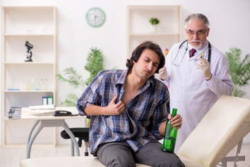 Obraz premium Young male alcoholic visiting old doctor
