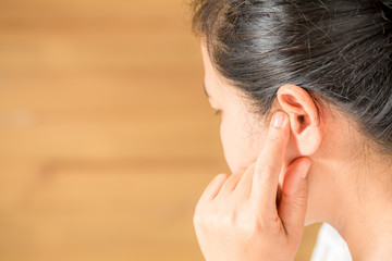 Female having ear pain touching his painful head