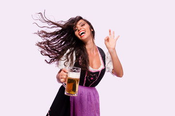 Charming curly hair young woman holding beer mug and waving, clean background