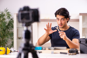 Fototapeta na wymiar Young male repairman recording video for his blog