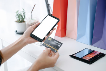 Mockup image of Beautiful woman holding credit card shopping online with smartphone on online websites, mockup concept