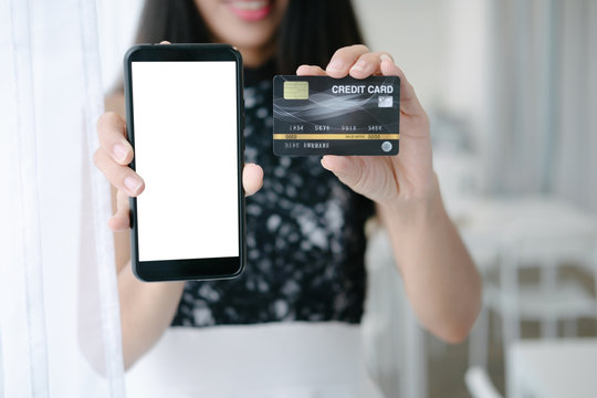 Mockup image of Beautiful woman holding credit card shopping online with smartphone on online websites, mockup concept