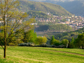 A valley with a town in a mountainous landscape - View framed by tree