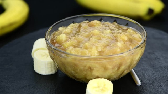 Mashed Bananas rotating on a wooden plate (not seamless loopable) in 4K UHD