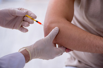 Male patient visitng doctor for shot inoculation