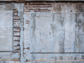 Old concrete wall with exposed iron reinforcement