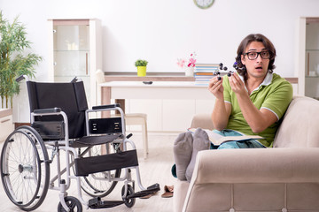 Young male student in wheelchair at home