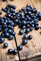 Billberries on the rustic wooden background. Selective focus. Shallow depth of field.