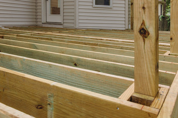 A new wooden, timber deck being constructed. it is on the decking.