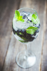 Billberry mojito cocktail in wine glass. Selective focus. Shallow depth of field.