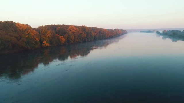 A river fully amidst a fog, filmed from above.