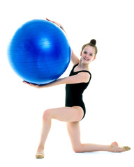 little girl doing exercises on a big ball for fitness.