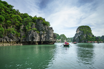 Halong bay in Vietnam, UNESCO World Heritage Site, with tourist rowing boats