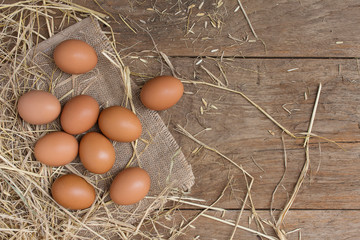 Fresh eggs from the farmer's farm have eggs and rice straw on the old wooden table.