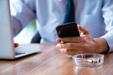 Male employee smoking cigarettes at workplace