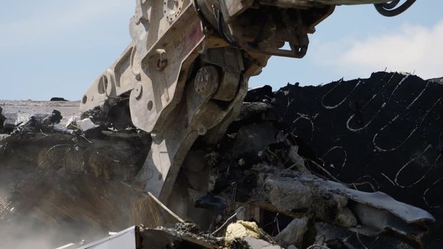 Close up of a Demolition machine tearing down roof of a condemned building.