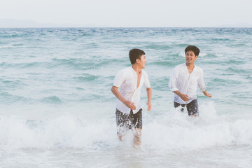 Homosexual portrait young asian couple running with cheerful together on beach in summer, asia gay going tourism for leisure and relax with happiness in vacation at sea, LGBT legal concept.