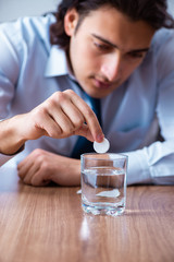 Sick male employee suffering in the office