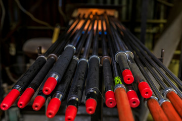 Glass blowing pipes warming up in a traditional furnace at a glass maker's workshop set up for the process