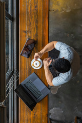 Vertical photo of young Asian millennial using laptop and tablet