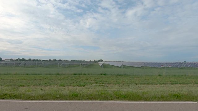 A drive down a country road reveals a solar farm surrounded by fields of crops as well as an oil tank at the end of the clip.