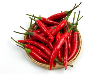 isolated red chilli peppers pile on  threshing basket  on white background