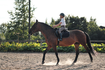 Girl teenager jockey trains on the field and at the hippodrome.