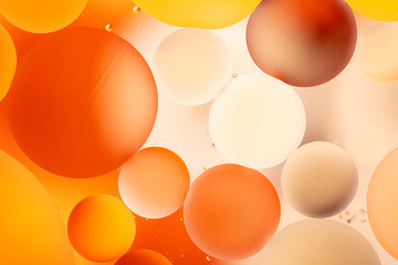 bright oily drops in water with colorful background, close-up 