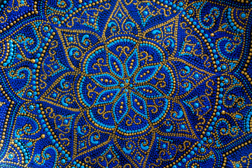 Decorative ceramic plate with blue and golden colors, painted plates, closeup. Decorative porcelain plate painted with acrylic paints, handwork