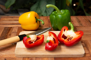Green Red and yellow peppers Slice on the cutting board on the old wooden floor