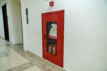 Fire extinguisher and fire hose reel in modern apartment