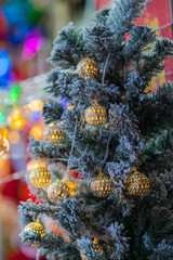 Decorated and illuminated christmas tree with warm toned ball and cold toned pine branches