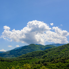 Mountain landscape with lonely clouds on a blue sky