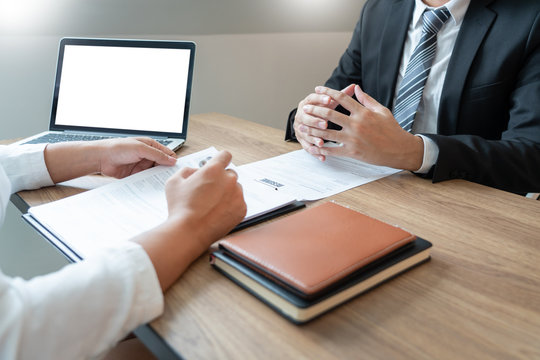 Serious man has a business meeting reading a resume about hiring decision during a job interview in company, attractive and professionally dressed, employment recruitment concept.
